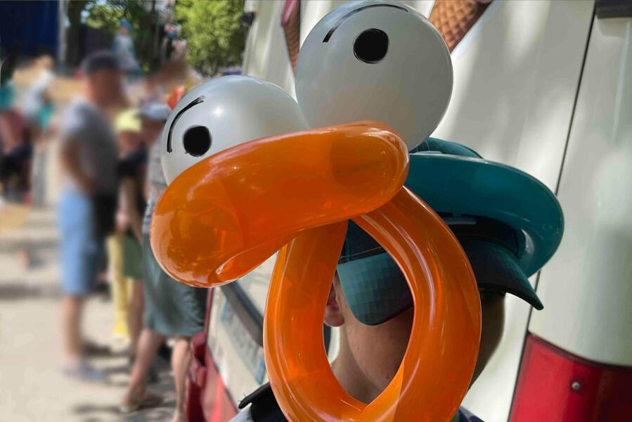 Un chapeau en sculpture de ballon pendant une fête estivale en extérieur