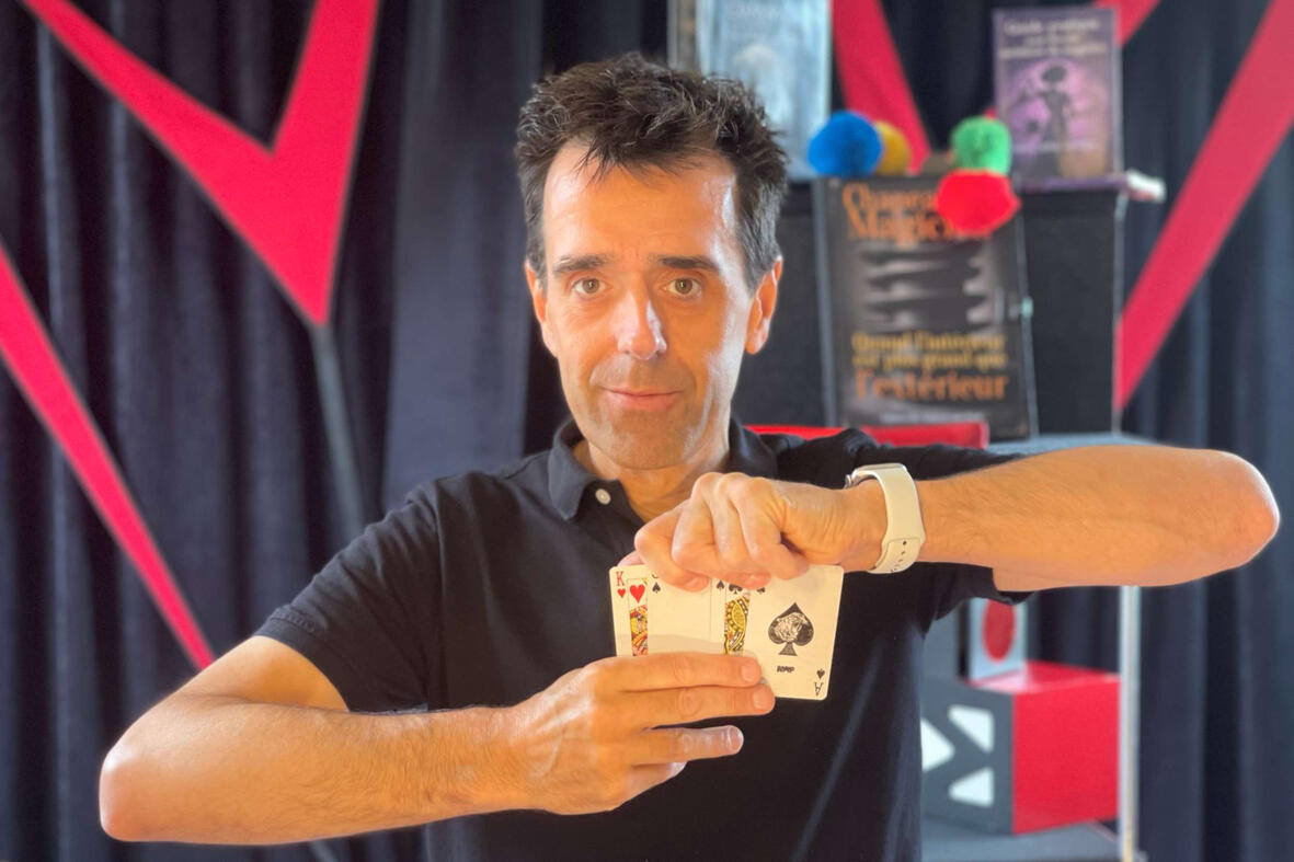 C'est magique ! Monsieur Fred réalise une prédiction mentaliste avec des cartes et un album à timbres lors d’un spectacle interactif pour enfants et familles.