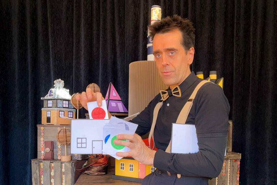 Risque-Tout Spectacle avec un déco, rempli de petites maisons avec le comédien qui a réalise son spectacle devant les enfants et la famille sur Paris
