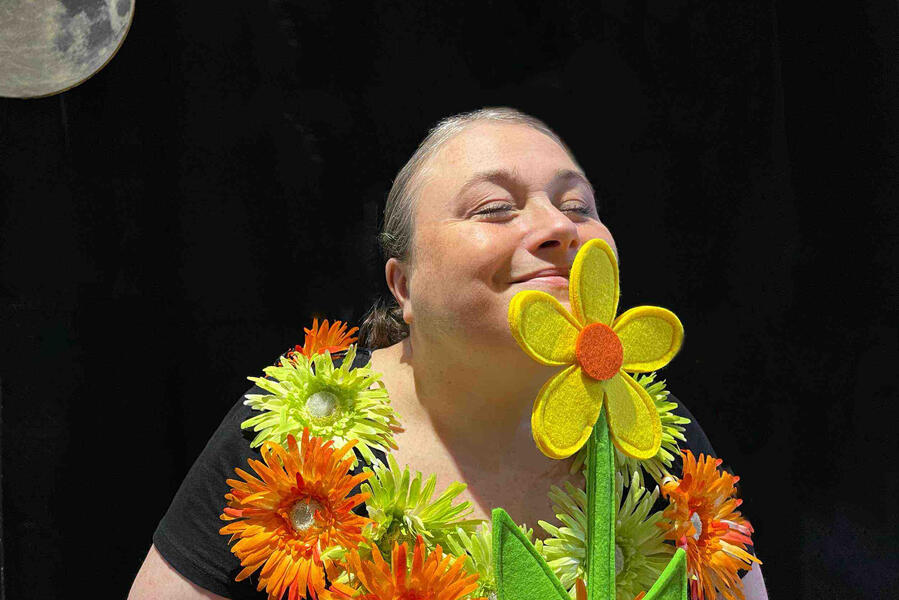 J'me cache ! Aurore est comédien est en train de se cacher est en train de sentir une fleur avec son beau costume lors d'un spectacle à Abbeville