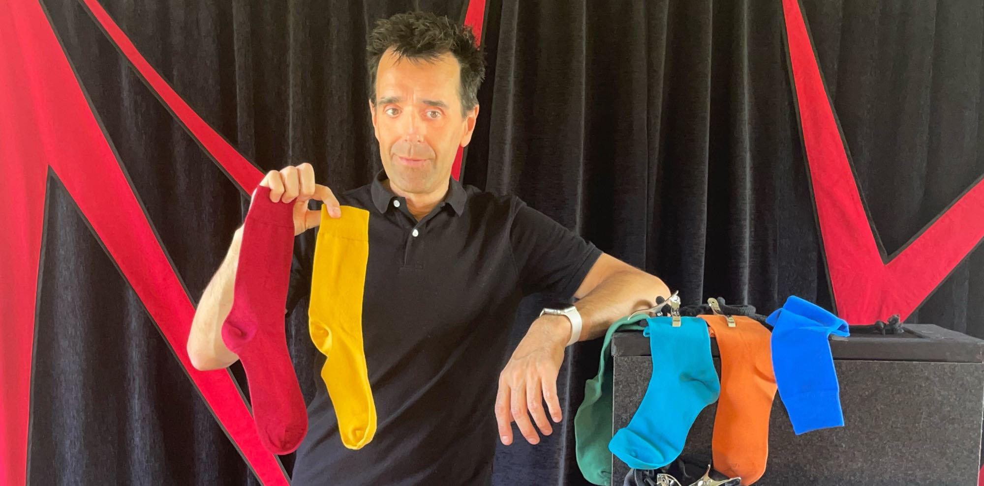 C'est magique ! Monsieur Fred fait apparaître un lapin en peluche à partir d’un foulard, entouré de ballons rouges, lors d’un numéro de magie pour enfants